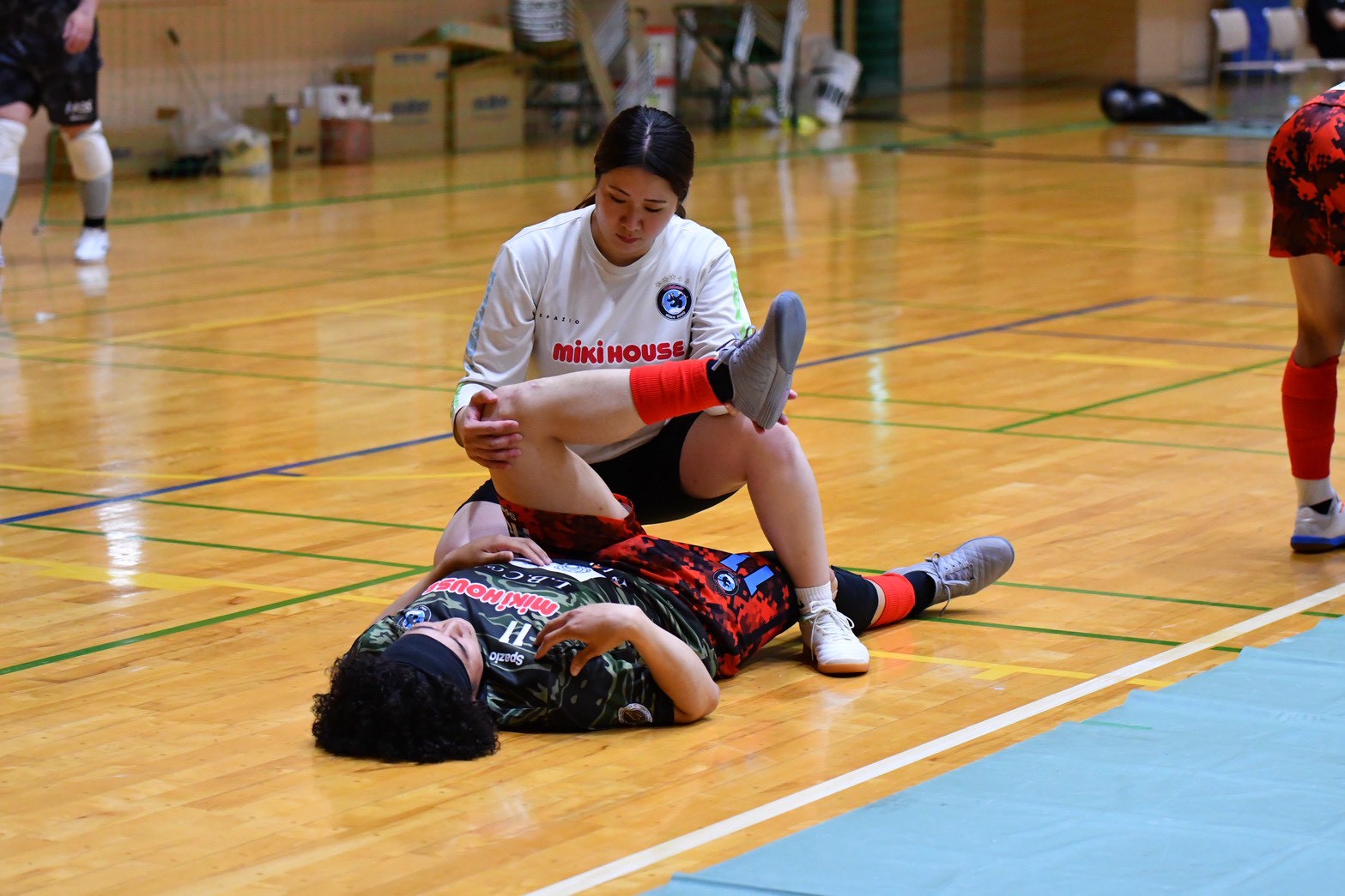 スポーツ現場で選手の脚の状態を確認する様子
